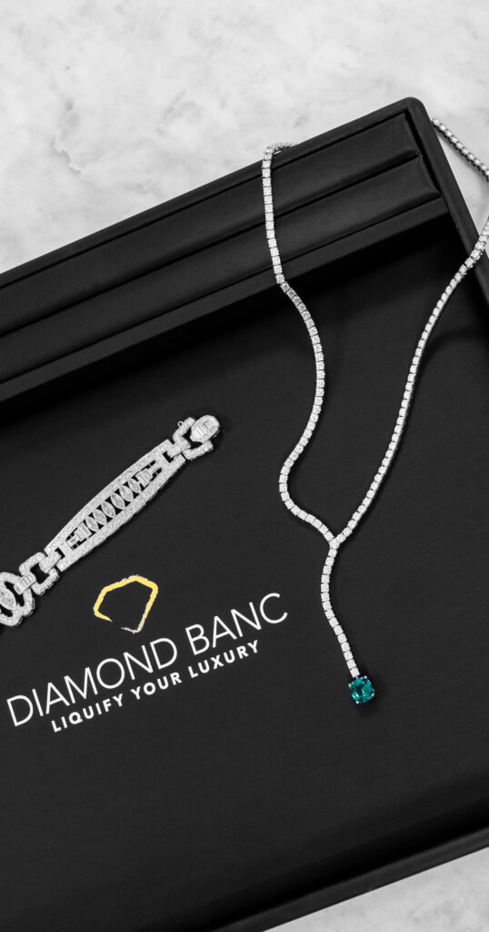 A Cartier diamond necklace with an emerald pendant and an estate diamond bracelet displayed on a black Diamond Banc branded jewelry pad. Diamond Banc is the premiere destination for clients in Sarasota looking to sell their Cartier jewelry and other designer pieces to Diamond Banc, a reputable jewelry buyer.