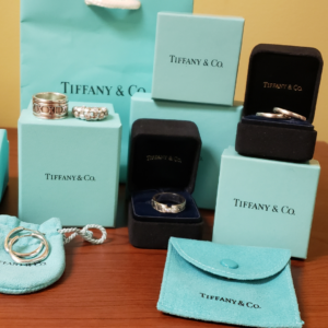 Collection of Tiffany & Co. jewelry displayed with signature blue boxes and pouches, including rings and accessories