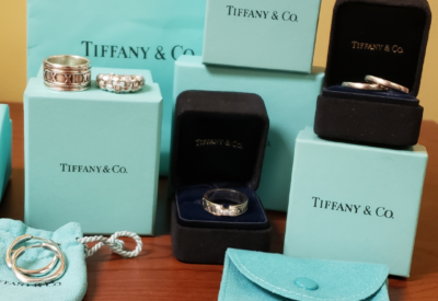 Collection of Tiffany & Co. jewelry displayed with signature blue boxes and pouches, including rings and accessories