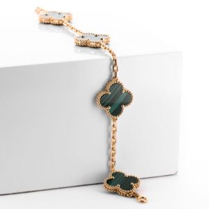 Van Cleef & Arpels Alhambra bracelet featuring green malachite clover motifs and gold detailing, ideal for those selling Van Cleef jewelry in St. Louis