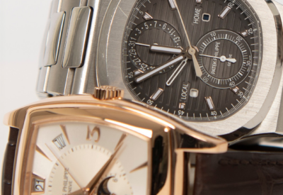 Close-up of two Patek Philippe watches, featuring a stainless steel Nautilus and a rose gold timepiece with a moonphase complication, showcasing luxury craftsmanship.